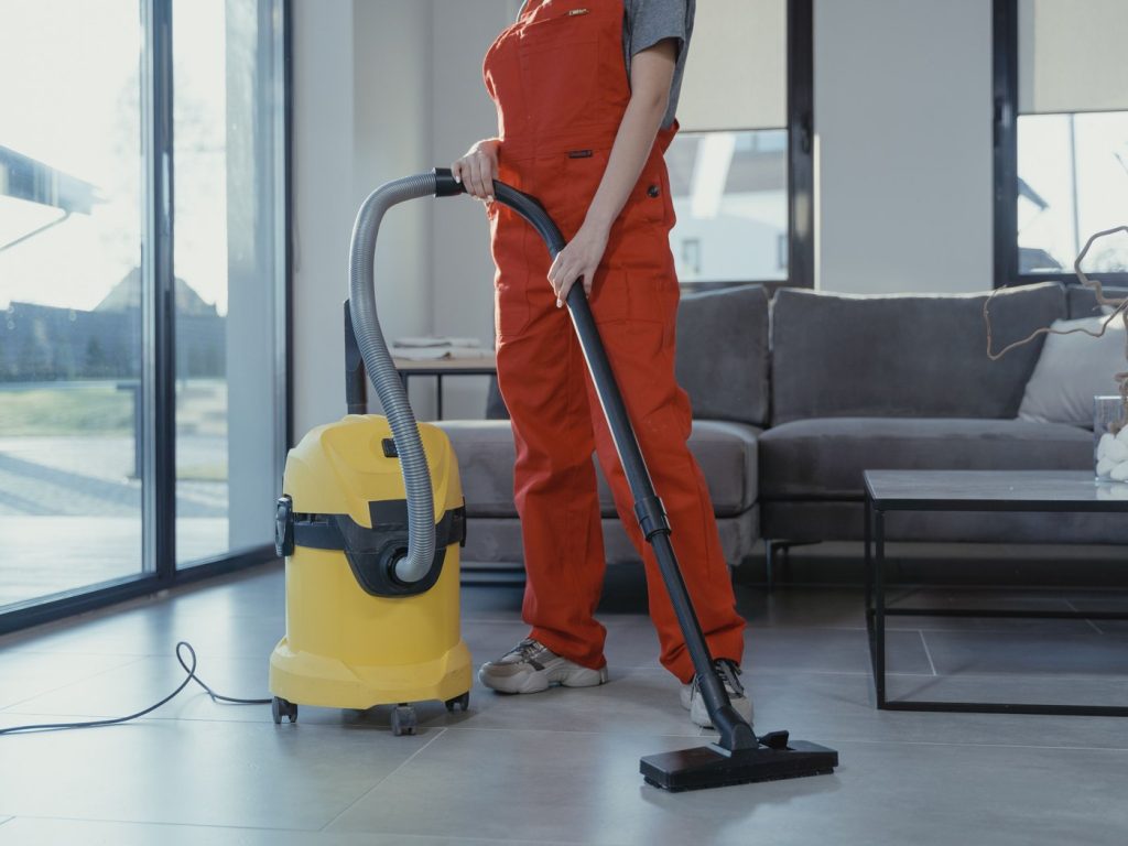 Büroreinigung: Reinigungskraft saugt Teppichboden in einem Büro