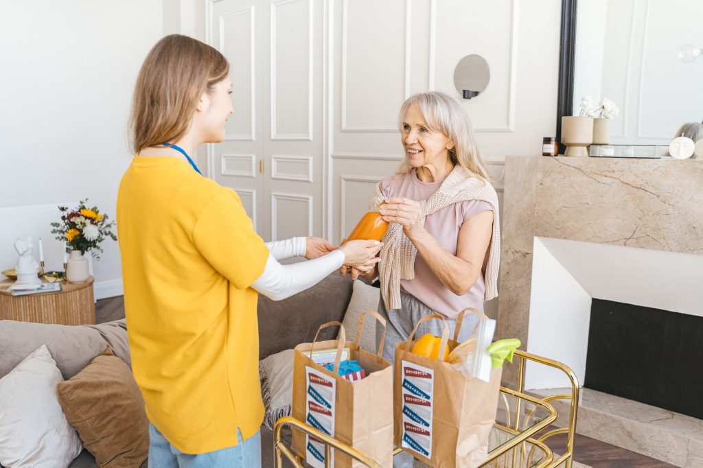 Haushaltshilfe bringt Einkäufe zu einer Seniorin