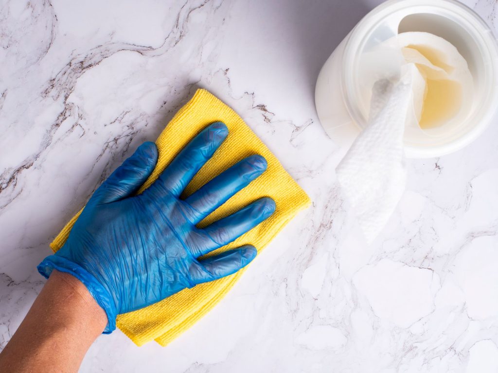 Hygienereinigung mit Handschuhen und Desinfektionsmittel