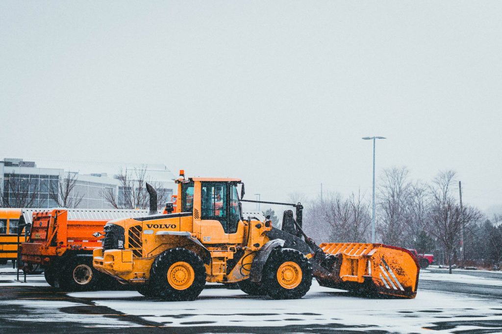 Räumfahrzeug beim Winterdienst auf einem Parkplatz